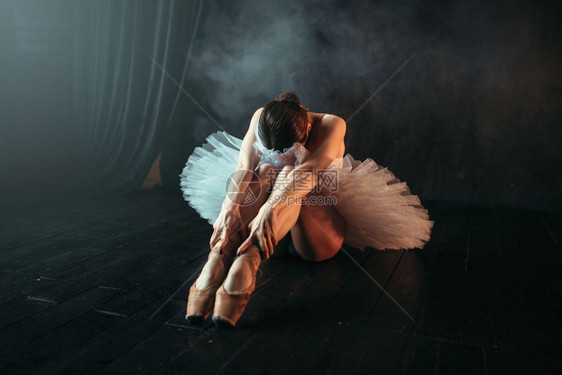 女芭蕾舞者坐在地板上图片