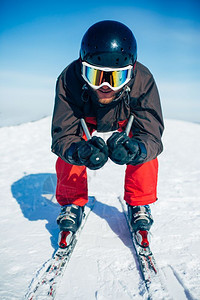 戴头盔和眼镜的滑雪者下坡滑雪图片