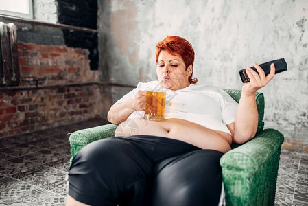 坐在椅子上喝啤酒高卡路里食品肥胖症不健康生活方式肥胖女图片