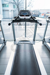 运动车对大窗户室内健身房没有人慢跑赛道固定运行模拟器动设备在健身俱乐部图片