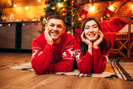 快乐的情侣趴在地板上庆祝圣诞节图片