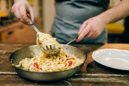 木制厨房桌上的锅子里装着自制传统的意大利，面图片