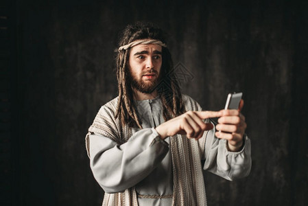 人类在基督的肖像中拥有手机黑暗背景图片
