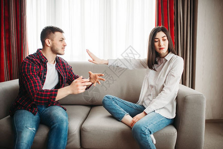 妻子坐在沙发上丈夫气愤对她大喊叫家庭冲突男女在争吵中不快乐丈夫对她大叫图片
