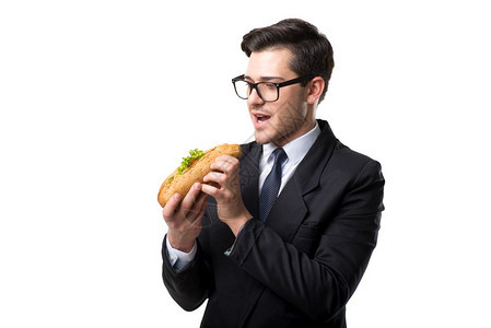 戴眼镜身穿领带和黑西装的商人在吃汉堡图片