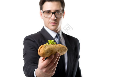 戴眼镜身穿领带和黑西装的商人在吃汉堡图片