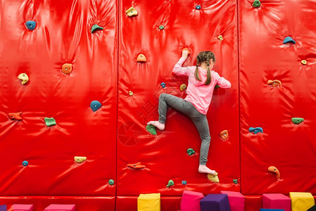 小女孩玩攀岩墙背景图片