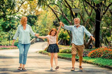 快乐的幸福家庭在公园的路上一起走图片