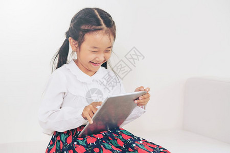 小女孩拿着平板本电脑笑的很开心图片