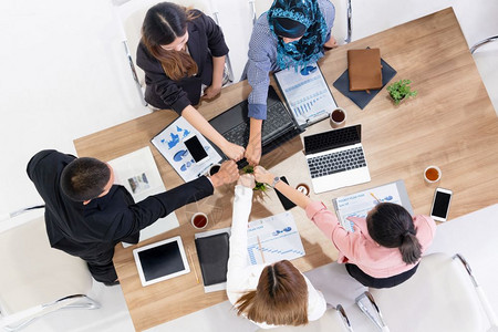 团队精神文化商人和女在多文化办公室的小组会议上携手合作展示企业的