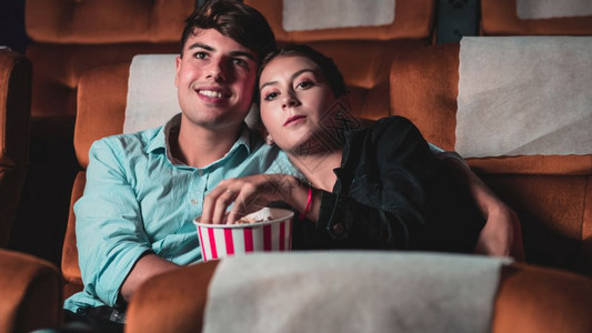 年轻夫妇在高兴的观看电影图片