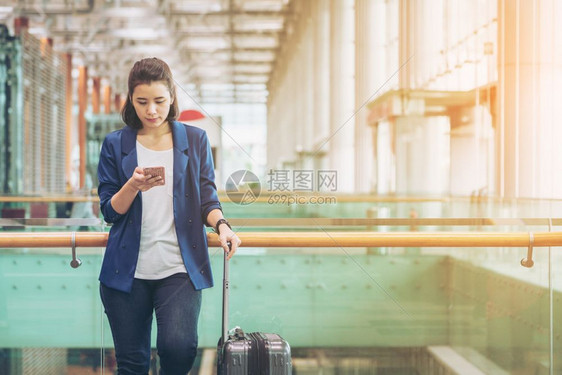 单身青年妇女在机场等候登机去旅行图片