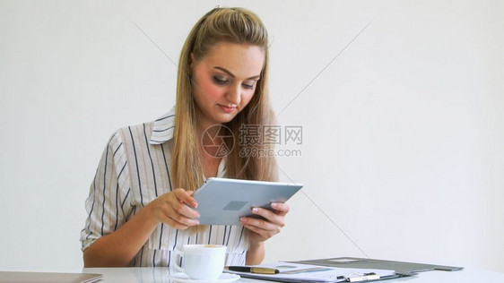 在办公室使用平板电脑工作的女白领图片