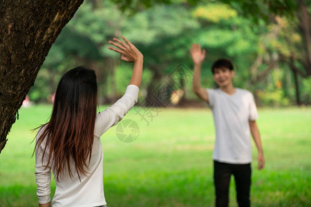 年轻人男女在公园中挥手打招呼图片