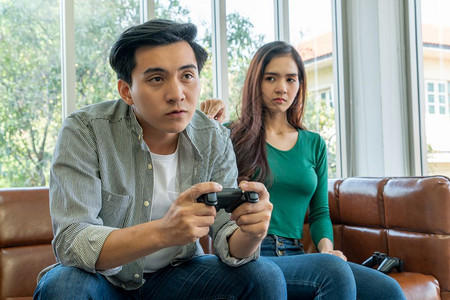 年幼的一对夫妇患有电脑游戏成瘾症家庭问题概念图片