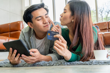 年轻夫妇使用信用卡在家中网购图片