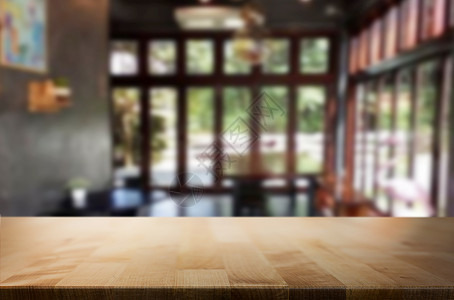 选中的空焦点棕色木制桌和咖啡店或餐馆背景模糊带有bokeh图像用于您的相片补装或产品显示图片