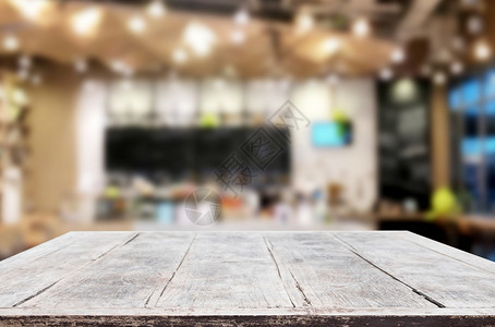 选中的空焦点棕色木制桌和咖啡店或餐馆背景模糊带有bokeh图像用于您的相片补装或产品显示图片