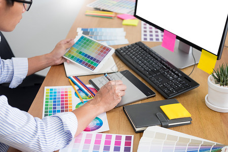 编辑设计师在工作室或办公与计算机一起坐在办公桌前的制图板和彩色调的新项目图片