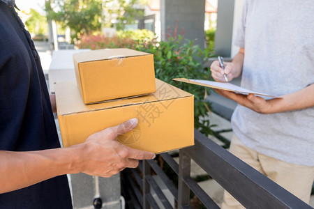 服务交付概念客户手从家中送货员处收到纸板箱包裹图片