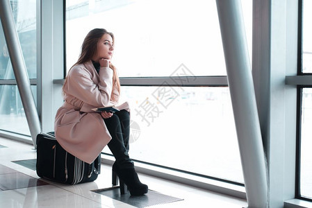 单身青年妇女在机场等候登机去旅行图片