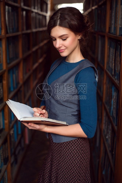 女学生在图书馆架之间看书图片