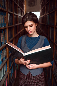 女学生在图书馆架之间看书图片