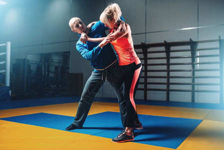 女人和男在自卫训练上打架体操斗武术架图片
