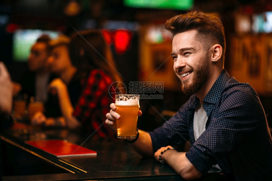 男子在酒吧的柜台喝啤酒图片