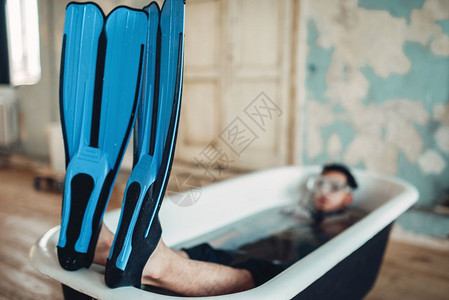 穿着拖鞋和面具的有趣商人躺在浴缸里幽默商业彩票概念图片