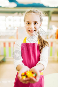 快乐的小女孩手握着手工制的焦糖果图片