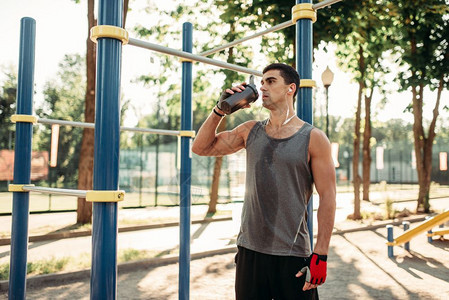 男运动员在户外健身训练后喝水图片