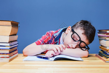 戴眼镜的小男孩趴在桌上睡觉图片