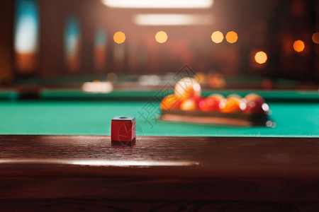 在台球桌的木边上白粉在背景的池三角中在台球桌边缘的粉笔背景图片
