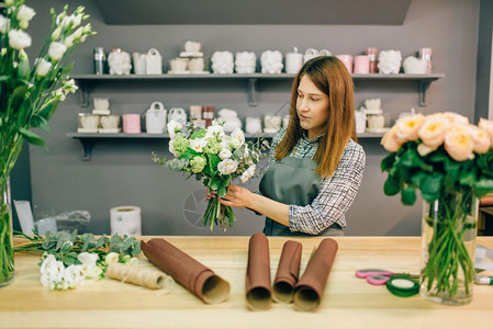 花卉企业束制作过程餐桌上装饰材料和工具图片