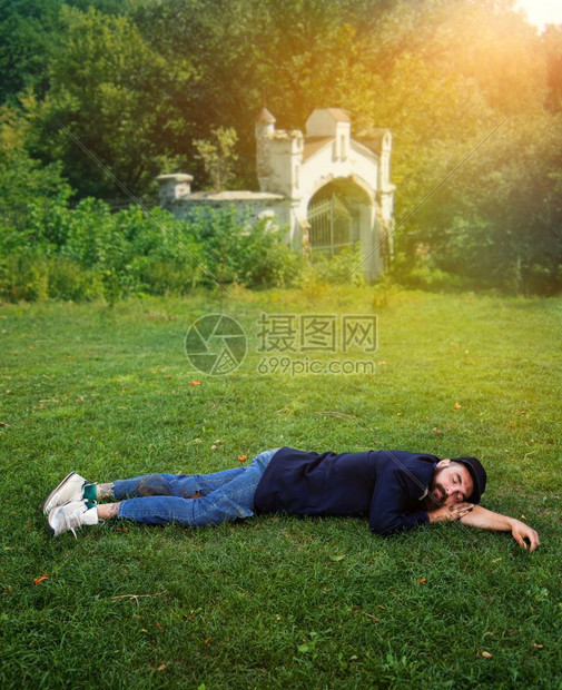 流浪者睡在绿草坪上图片