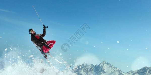 戴眼镜的滑雪者跳起滑行图片