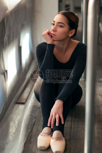 女芭蕾舞蹈者坐地板上休息图片
