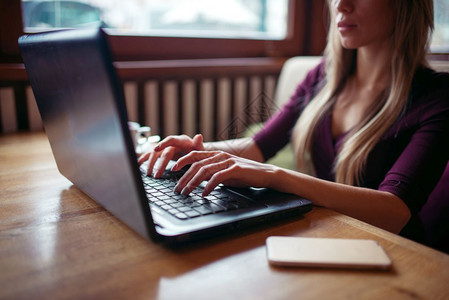 女青年在咖啡馆使用笔记本电脑图片