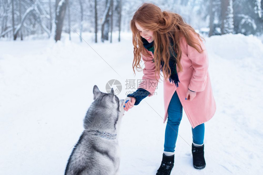 ‘~下雪的冬天年轻女子带着狗狗在公园一起玩耍  ~’ 的图片