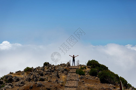 女人举起手站在山峰日落时站在山峰上女人站在山峰上图片