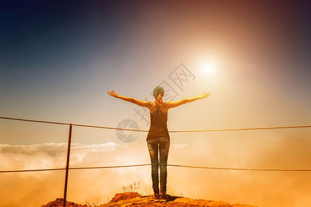 女人站在阴云的山顶上日落时有栅栏脚下印山顶上女人图片