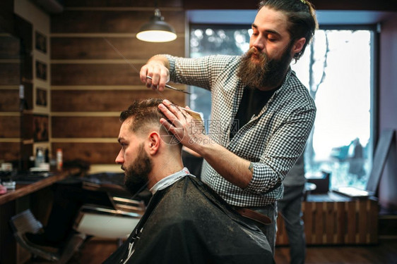 用剪刀下男客户的发型在理店穿黑沙龙披风的男人图片