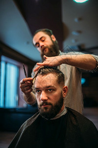 黑沙发披风的客户男子参观理发店胡须师参观男时装发型图片
