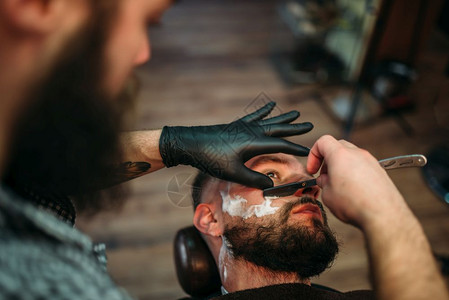 理发师用剃刀刮客户的胡子图片