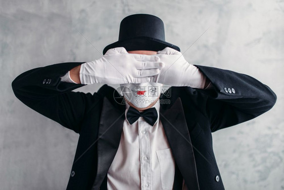 马戏团艺术家装扮带白化妆面罩的全色装饰喜剧演员穿西装手套和帽子图片