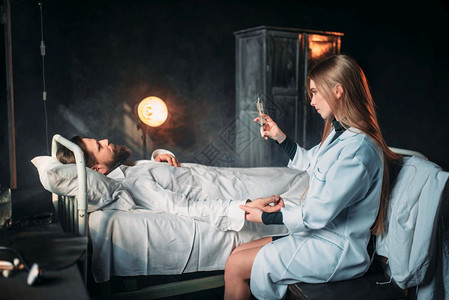 女医生用注射器对着病床上的男病人图片