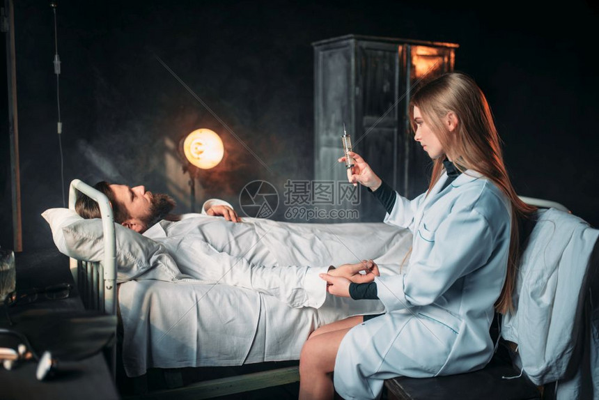 女医生用注射器对着病床上的男病人图片
