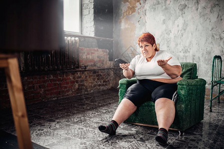 胖女人坐在椅子上看电视不健康的生活方式肥胖症图片