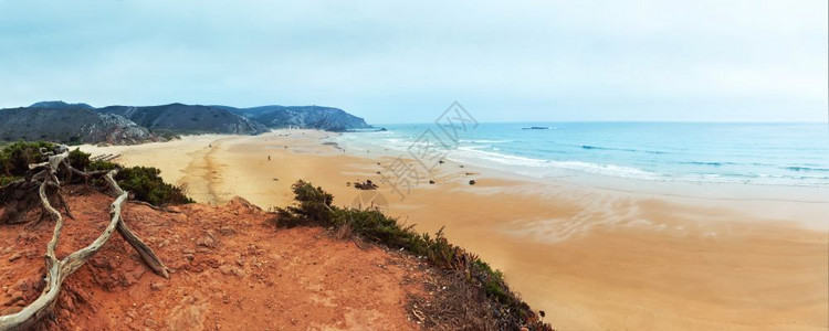 宁静的海岸线靠近山顶阴云多的天脚下平静的海图片